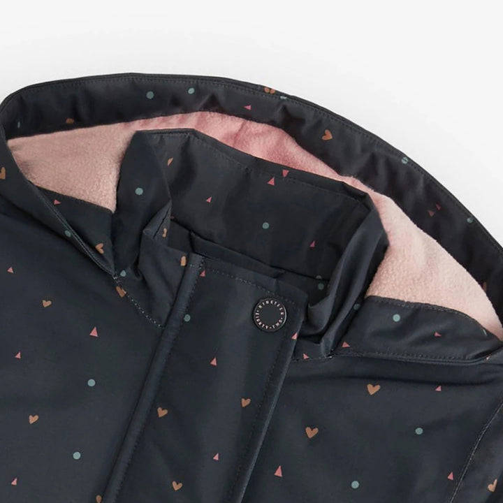 Close-up of pink-lined hood and navy heart print on girls hooded zip jacket