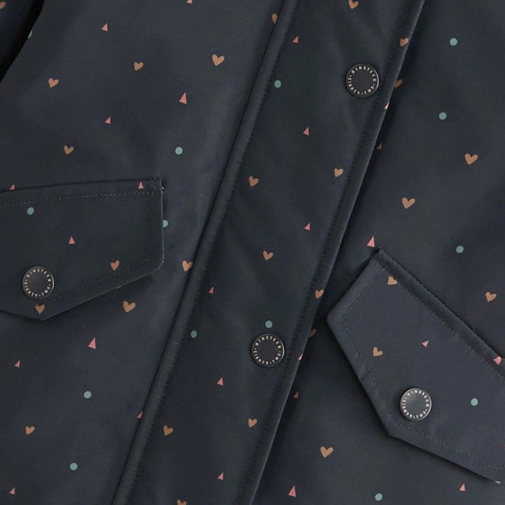 Close-up of snap-button front and flap pockets on girls navy heart print hooded jacket