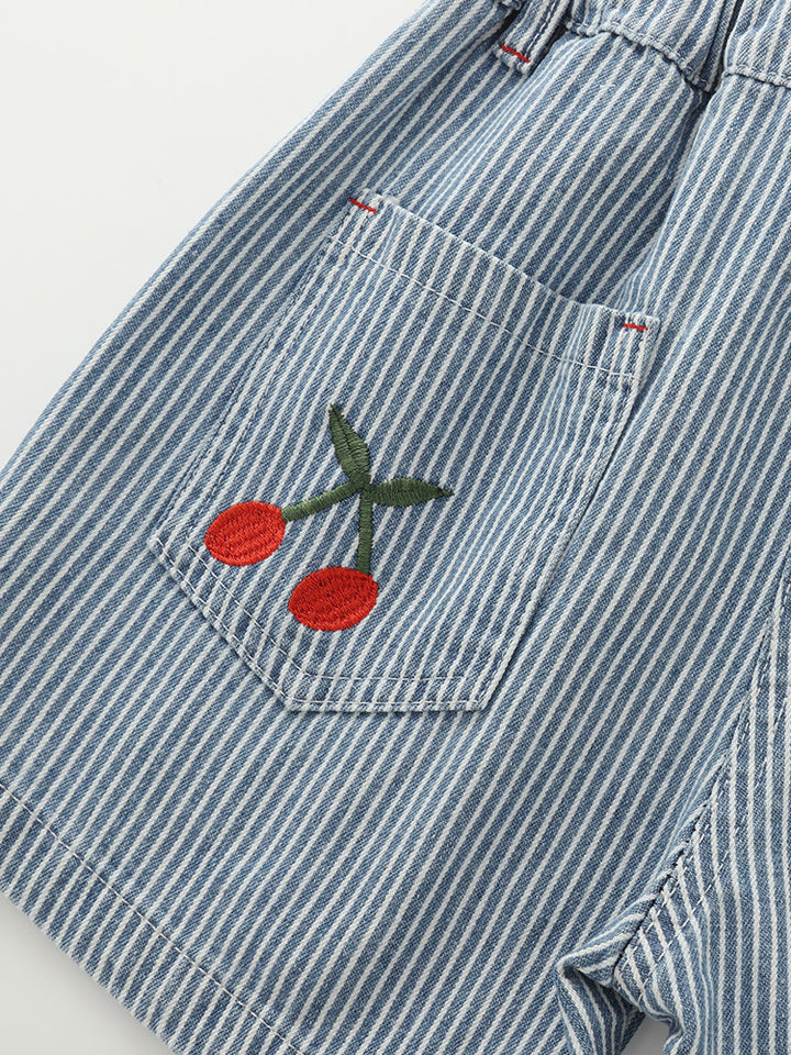 Close-up of cherry embroidery, rear pocket stitching and blue stripe fabric on Girls’ cotton shorts