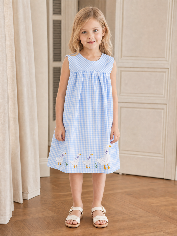 Girl wearing a sky blue gingham sleeveless dress with three goslings followed by a larger mother goose embroidery