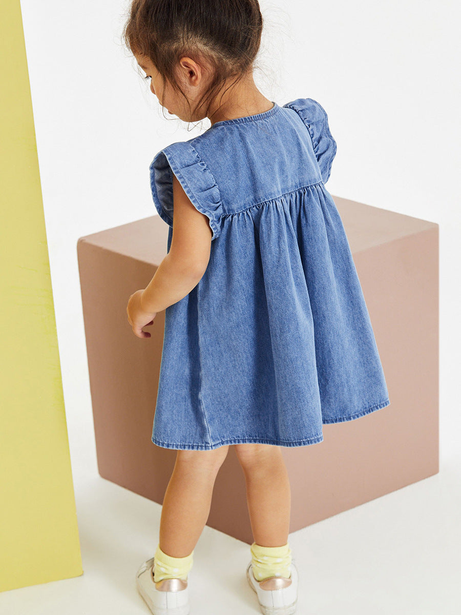Close-up of colorful cloud, sunshine, tulip and dinosaur appliqués on a girls blue jean dress