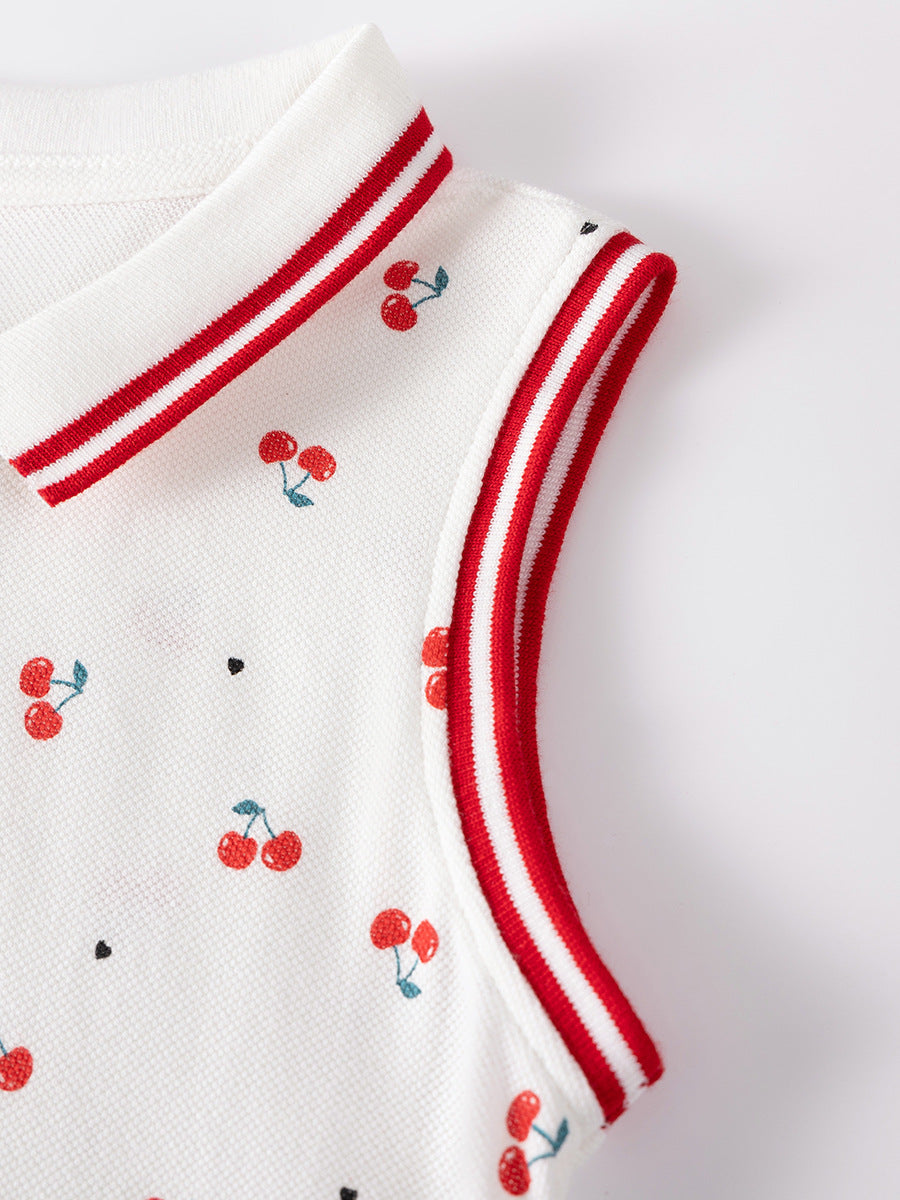 Close-up of red striped trim and cherry print on girls white piqué cotton dress