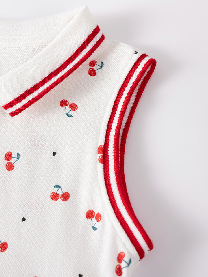 Close-up of red striped trim and cherry print on girls white piqué cotton dress
